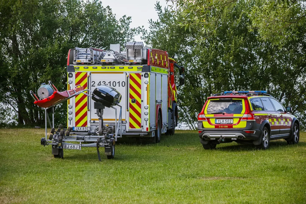 Räddningstjänst och ambulans vid Osets badplats i Huskvarna efter larm om befarad båtolycka där två personer behövde hjälp in till land.
